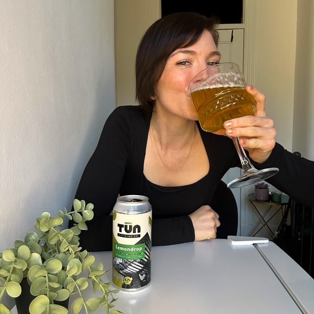 Enjoying a glass of beer with a Lemondrop can on the table